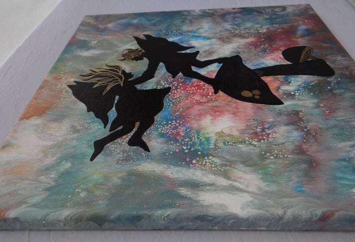 Angled perspective of a 12"x12" acrylic pour painting featuring silhouetted fairies with gold accents standing on a mushroom, set against a cosmic, swirling abstract background.