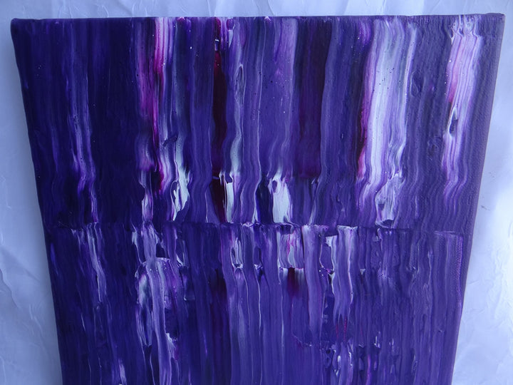 Close-up of Purple Stripe, a 10"x10" acrylic pour painting featuring deep purple hues with streaks of black, white, and magenta. The fluid swipe technique creates a layered, textured effect, highlighting the depth and movement of the paint.
