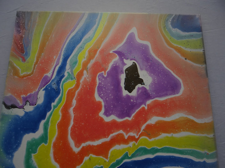 Close-up of Rainbow Geode, showcasing the luminous, shifting colors and organic fluid layers.