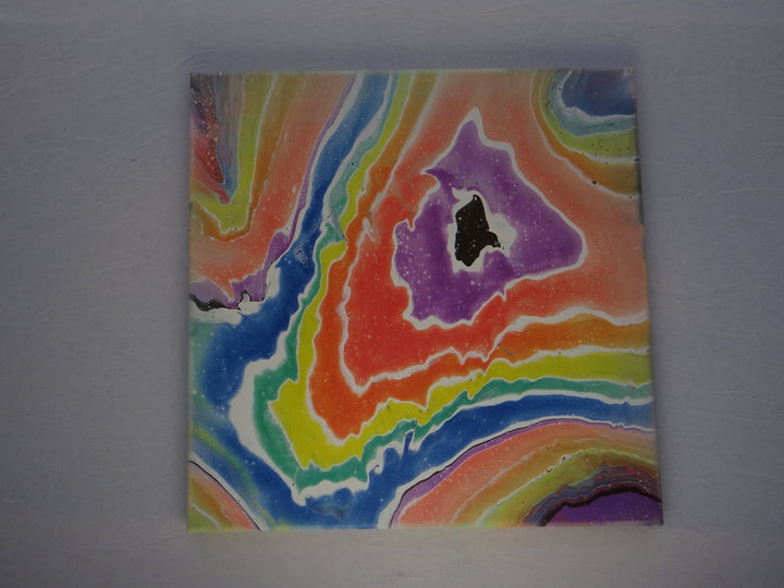 Abstract 12"x12" acrylic pour painting with vibrant, flowing rainbow hues and a gemstone-inspired design, ready to display.